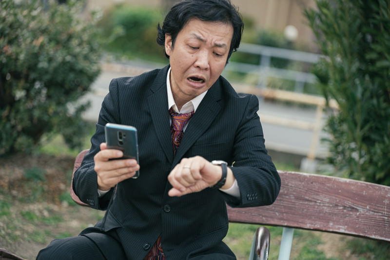 スマホで時間を確認する様子